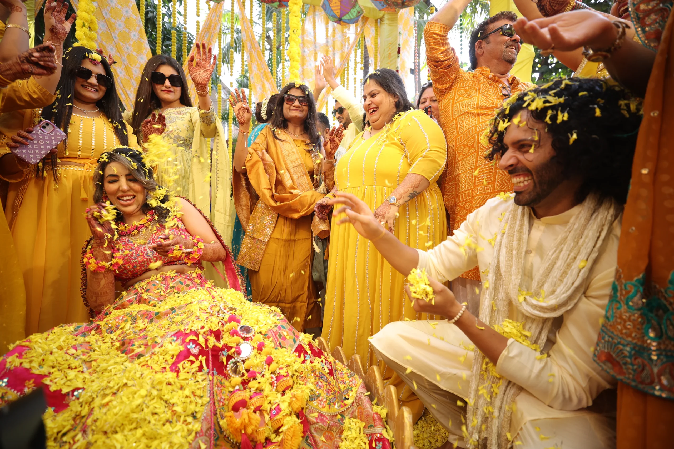 Vibrant Haldi ceremony with bride and groom, yellow flowers, joyful Indian wedding photography Rajkot